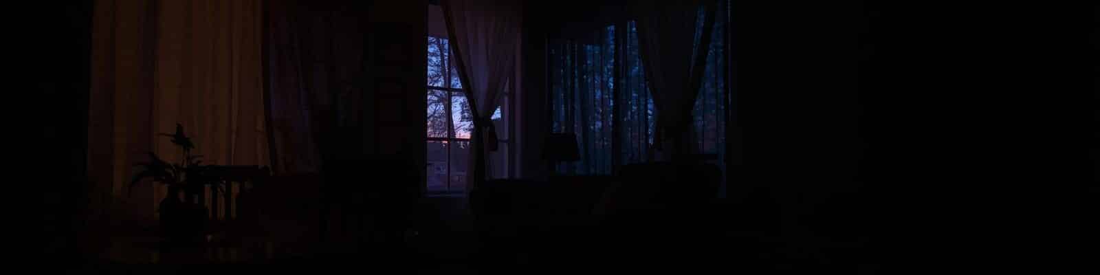 Residencia com luzes apagadas e uma janela de fundo
