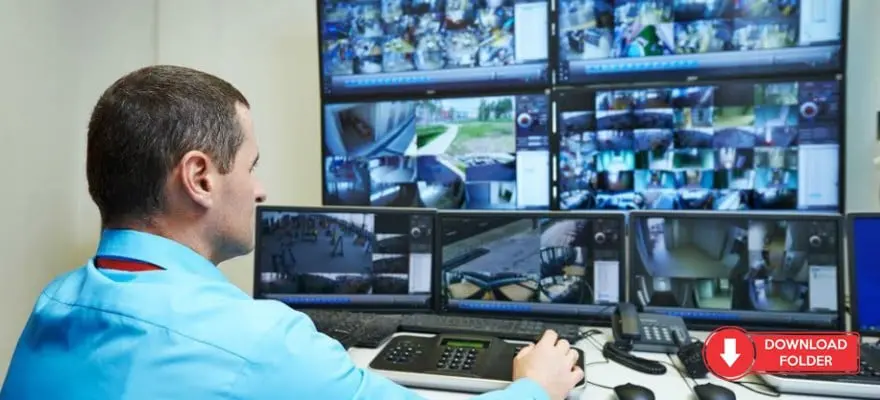 Técnico de segurança ou vigilância monitorando várias telas de CFTV em uma sala de controle, com múltiplos monitores mostrando feeds de câmeras de segurança