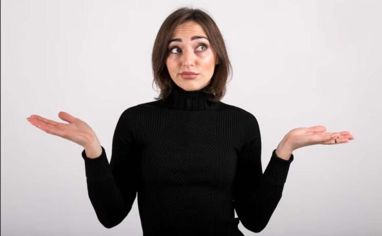 mulher com os braços abertos fazendo sinal de dúvida