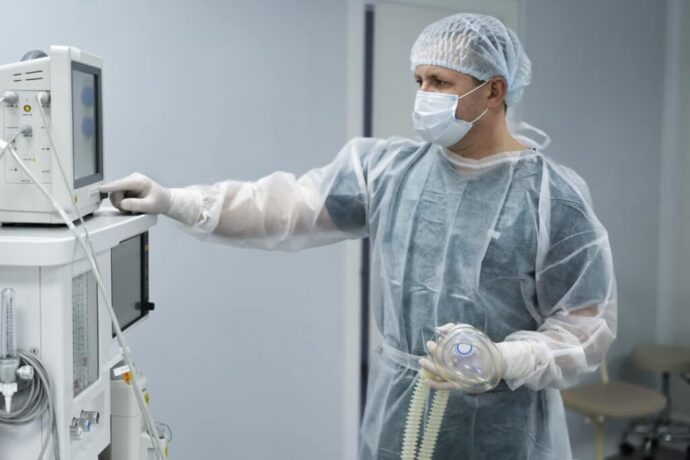 um médico ao lado de um equipamento hospitalar