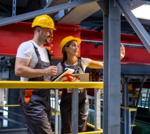 dois funcionários trabalhando em industria com equipamentos de proteção