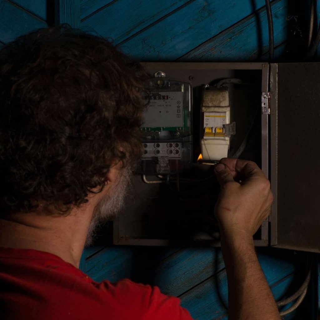 um homem mexendo no registro de energia de sua casa