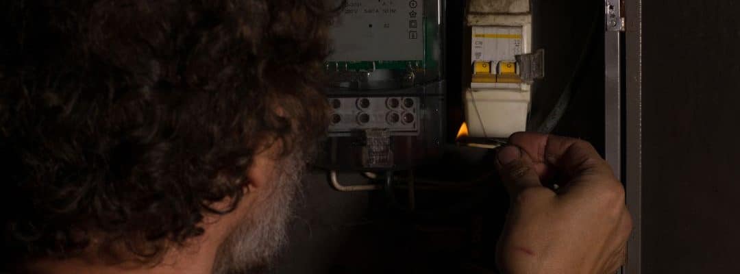 um homem mexendo no registro de energia de sua casa