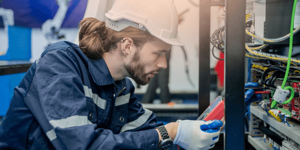 um rapaz equipado fazendo manutenção na energia elétrica