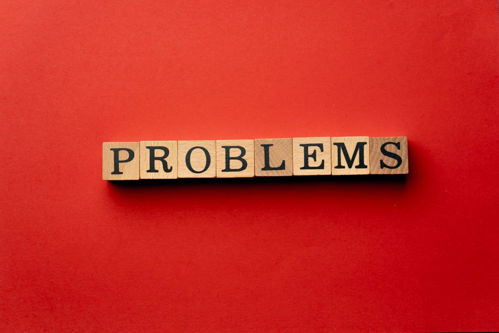 dados com letras formando a palavra problemas, em um fundo vermelho