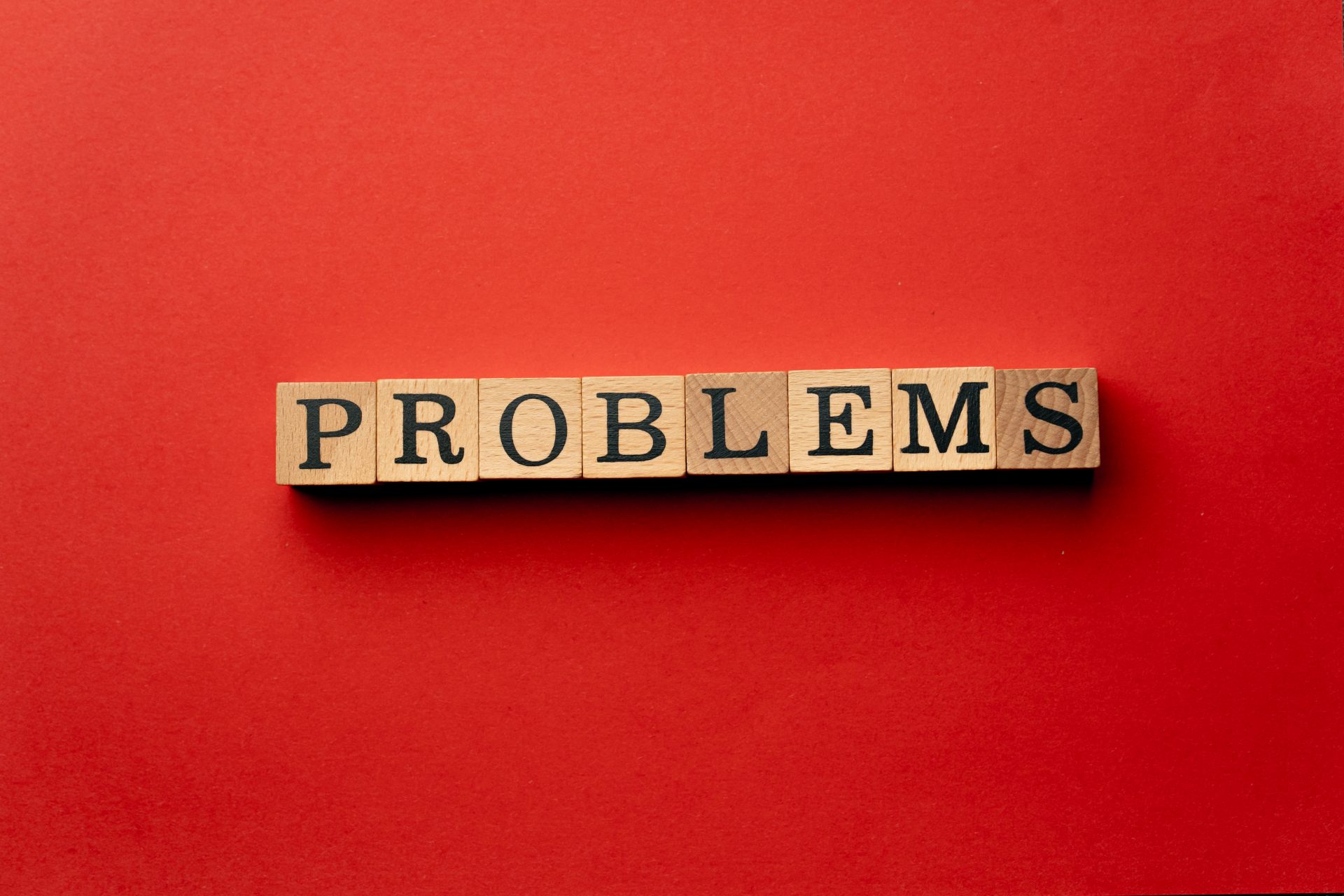 dados com letras formando a palavra problemas, em um fundo vermelho