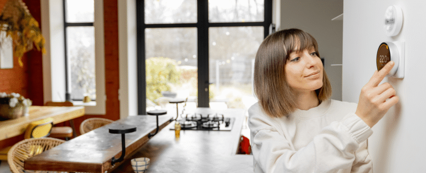 uma mulher em casa arrumando seu sistema de automação residencial