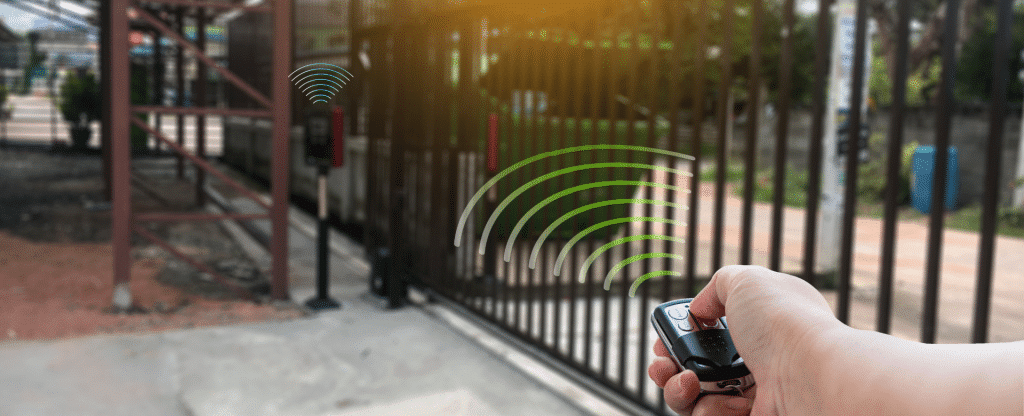 um fundo de portão eletronico e uma pessoa segurando um controle para abrir o portão