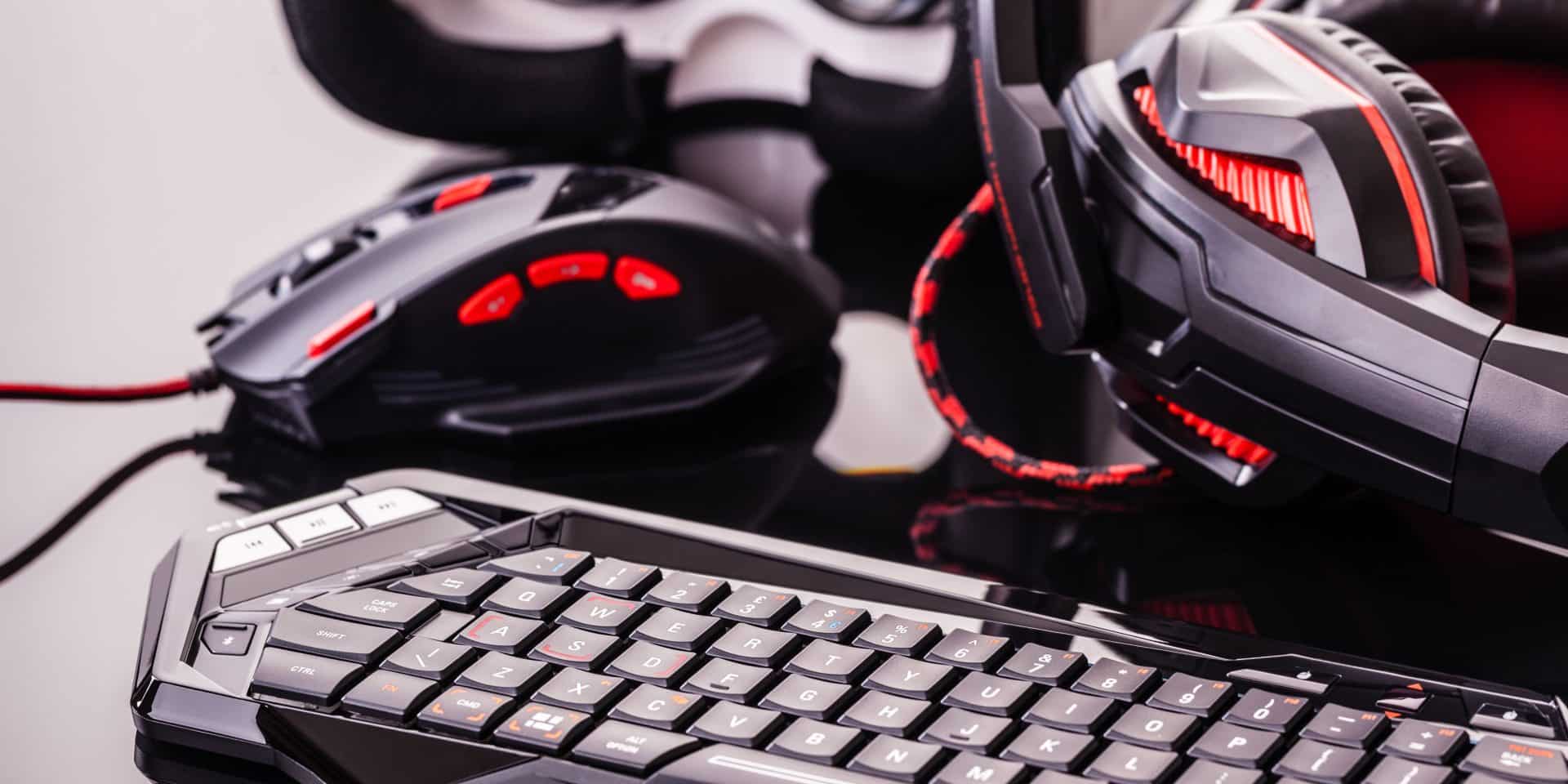 um teclado de computador com um mouse e um headphone, tipo um pc gamer