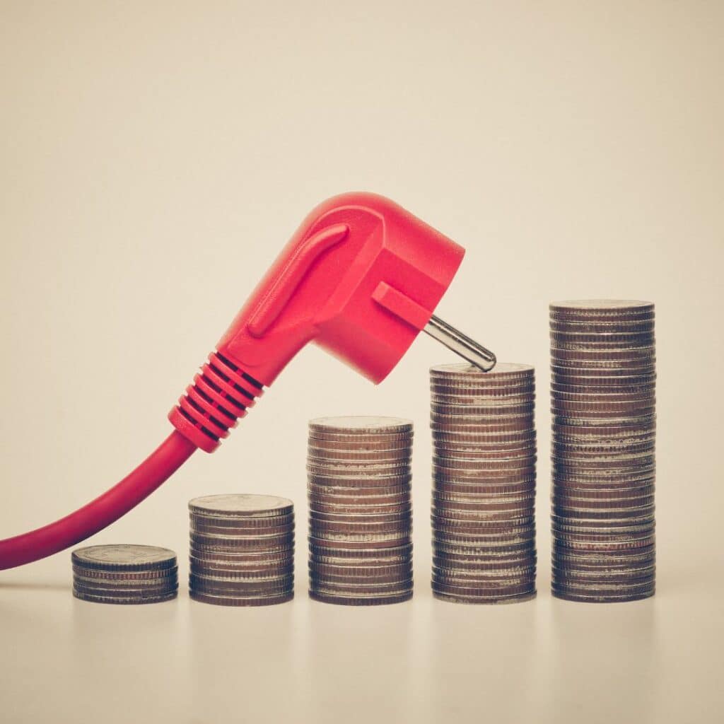 um fio de tomada vermelho em cima de uma "escadinha" de moedas