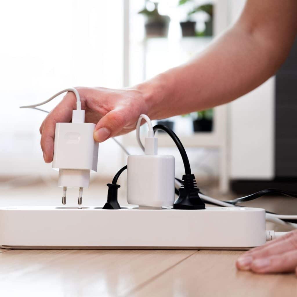 imagem de uma mão conectando algo a um filtro de linha com outras conexões