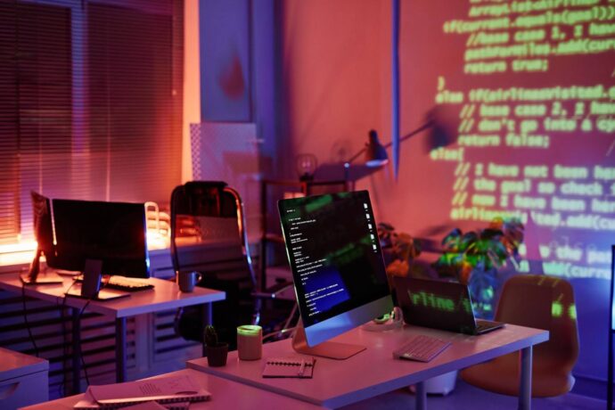 uma sala com um pc e um projetor na parede