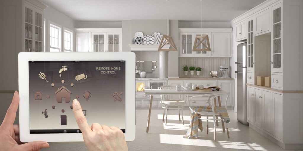 uma pessoa segurando um tablet em frente a uma cozinha, fazendo uma automação