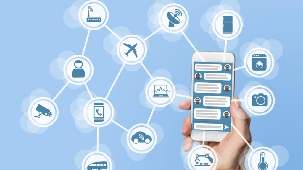 uma mão segurando um smartphone e vários ícones de tecnologia saindo por ele