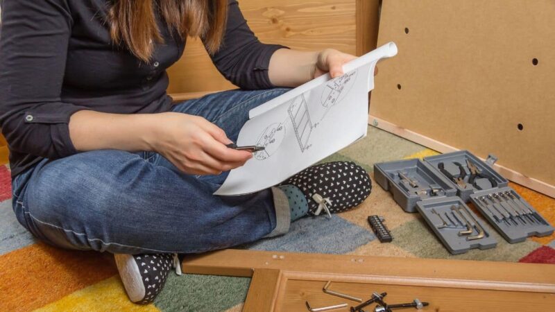 uma mulher sentada lendo um manual de instruções