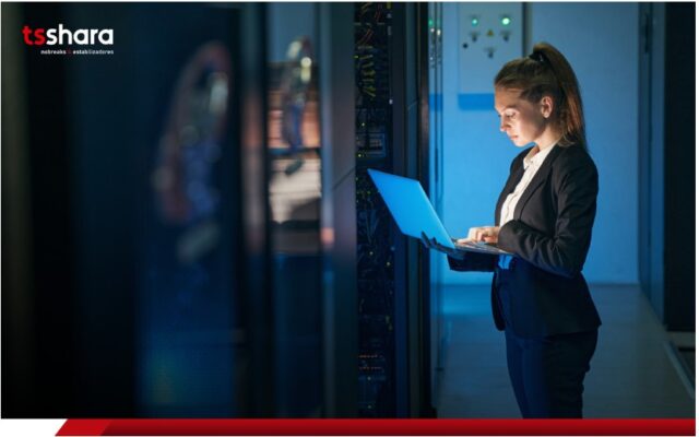 Técnica em TI com notebook em data center.
