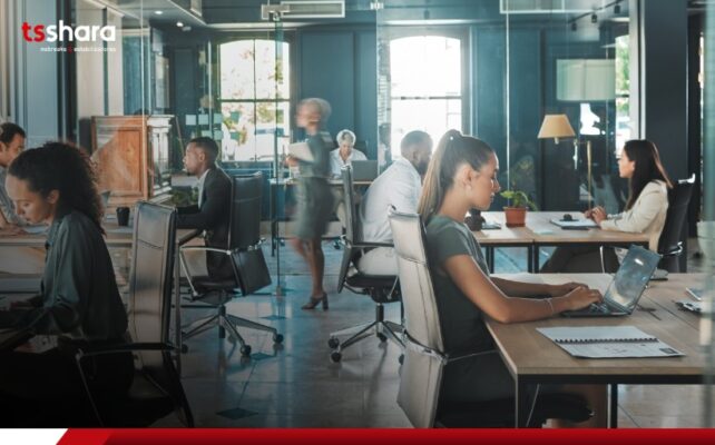 Escritório moderno com pessoas trabalhando em estações de trabalho.