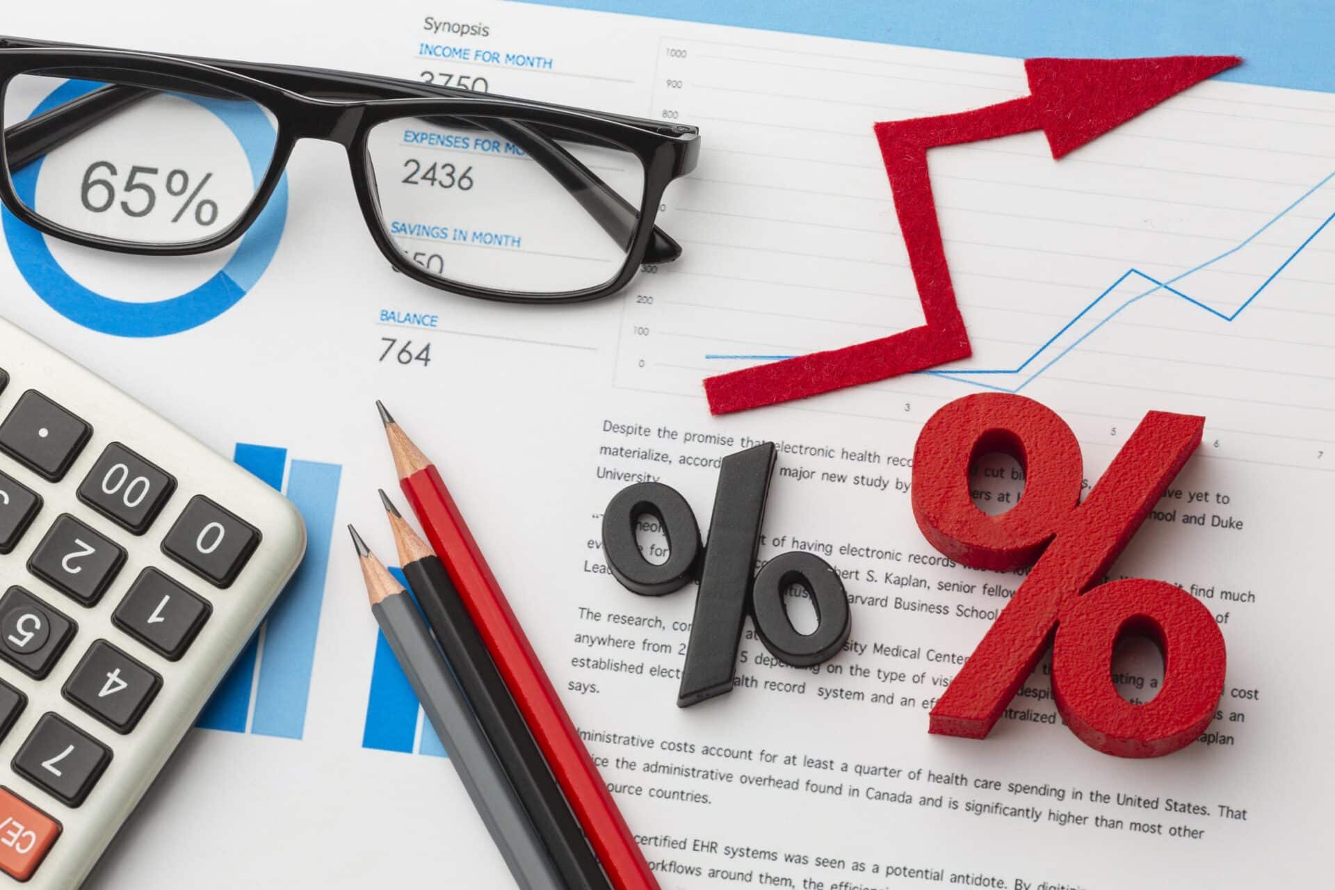 imagem de uma calculadora com um oculos em uma mesa e sinais de porcentagem