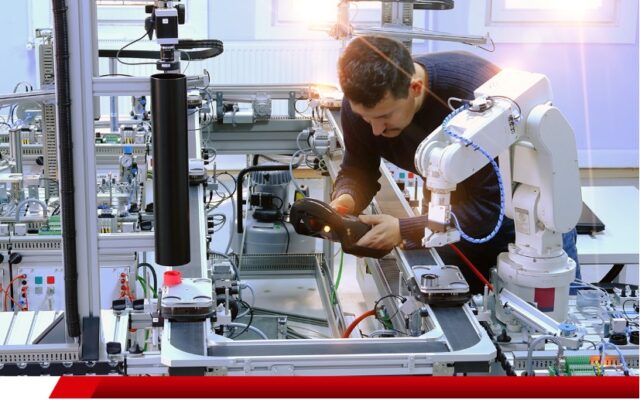 Técnico operando sistema de automação com braço robótico.