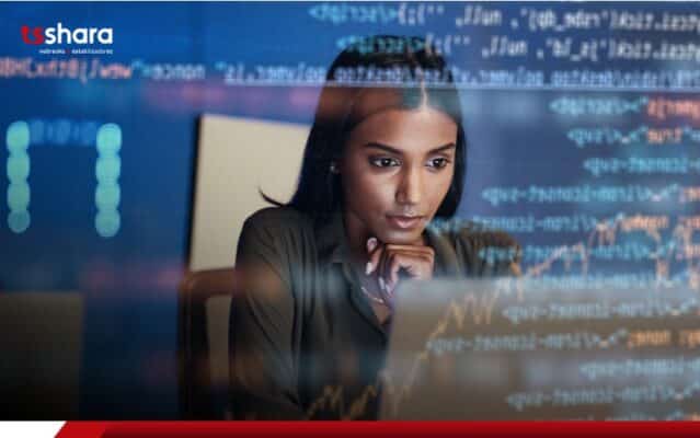 Analista de TI usando notebook com gráficos e códigos.