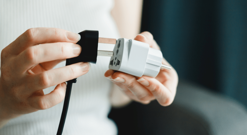 uma pessoa ligando uma tomada com adaptador tipo t