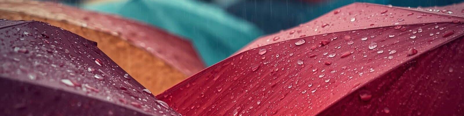 Fotografia em plano médio de um carro elétrico preto sendo carregado em uma estação de recarga ao ar livre durante o entardecer. O cabo de energia está conectado à lateral traseira do veículo, que exibe as lanternas acesas em um tom vermelho vibrante.