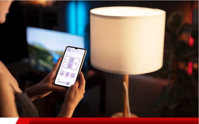 Pessoa controlando lâmpada por aplicativo no celular