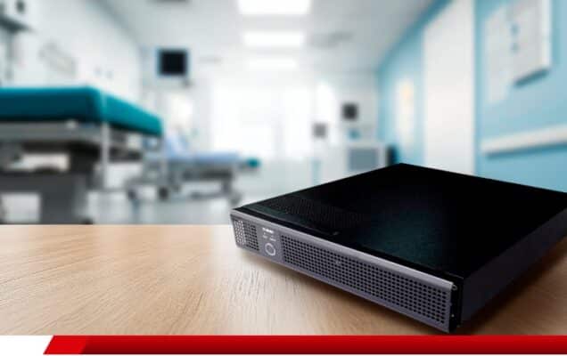 Nobreak em rack sobre mesa com fundo de sala hospitalar