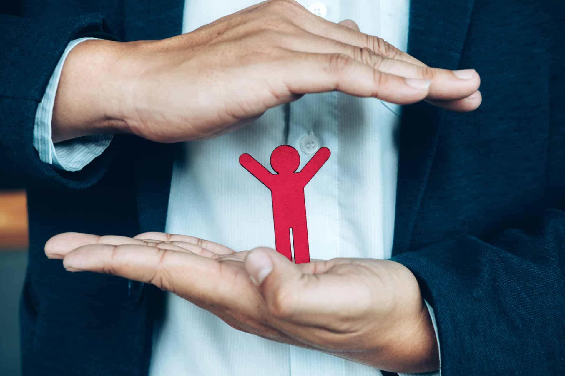 um papel em formato de pessoa na mão de um homem