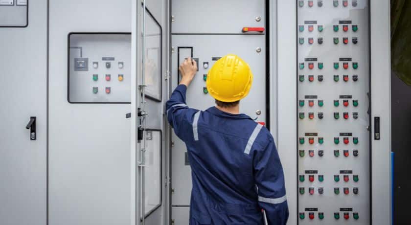 um eletricista fazendo manutenção em uma caixa de energia