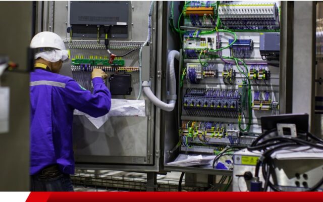 écnico realizando manutenção em painel elétrico