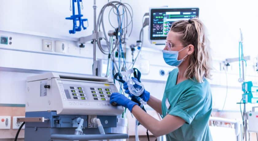 uma profissional da area da sáude ajustando equipamentos hospitalares