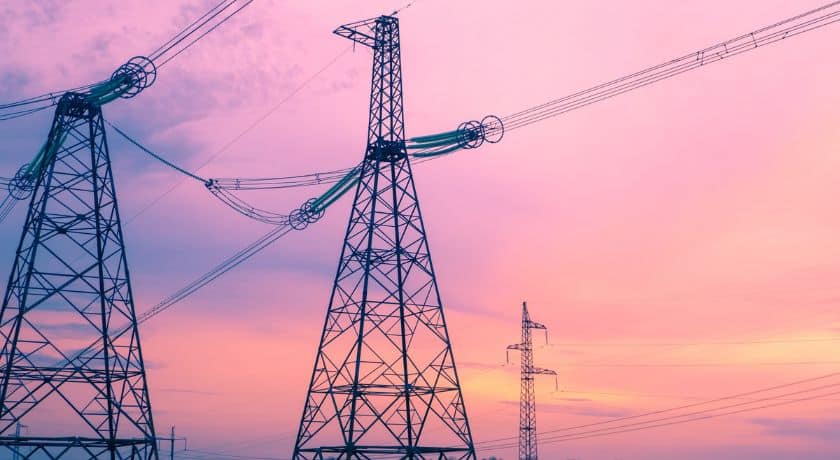duas torres de energia elétrica em um fundo de entardecer