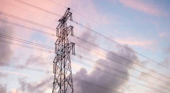 foto de uma torre de energia elétrica e um céu com muitas nuvens 