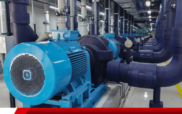 Motores elétricos acoplados a bombas industriais em linha dentro de sala técnica