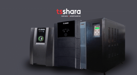 A imagem mostra três modelos de nobreaks TS Shara. Eles estão dispostos de forma horizontal, com cada modelo exibindo um design distinto. O primeiro modelo, à esquerda, possui um display simples e um design mais compacto. O modelo central apresenta um painel de controle maior e um design um pouco mais robusto. O modelo à direita é um dispositivo maior, com uma tela de controle detalhada e mais recursos visíveis. O fundo da imagem é escuro, destacando os produtos.