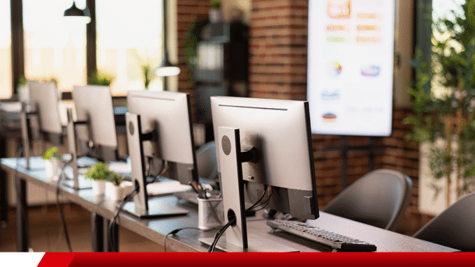 Monitores e estações de trabalho alinhados em escritório moderno.