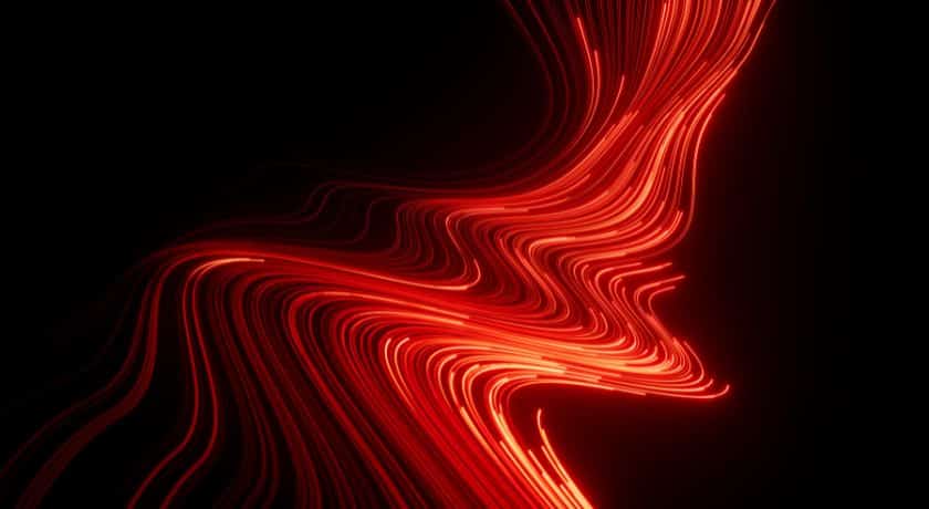 Imagem abstrata com linhas finas e brilhantes de cor vermelha intensa que se movem em ondas e curvas fluidas contra um fundo preto sólido.