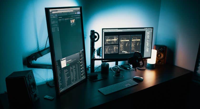 Setup de computador moderno e minimalista com dois monitores em uma mesa.