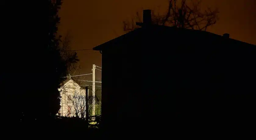 Cenário de apagão urbano durante a noite. A imagem destaca uma residência completamente às escuras