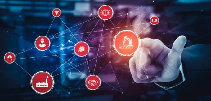 Representada pela rede de nós interconectados, sugerindo que máquinas, sensores e sistemas de gestão comunicam-se em tempo real.