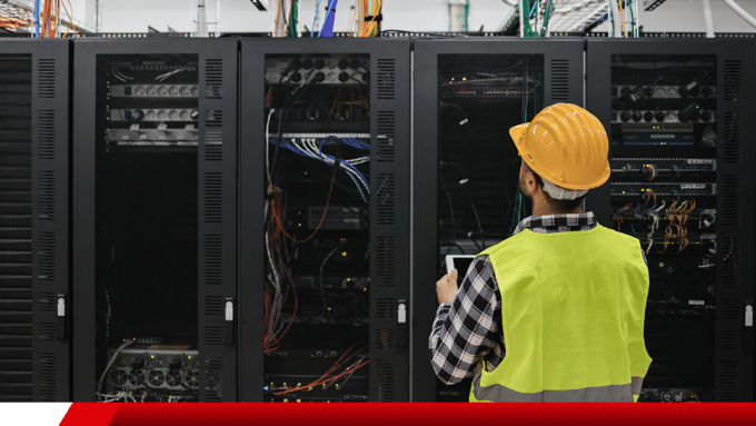 Técnico inspecionando racks de servidores em data center.