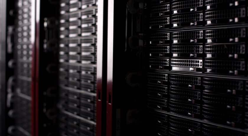 Close-up de racks de servidores pretos em um data center moderno, destacando a infraestrutura de TI, armazenamento de dados e sistemas de rede