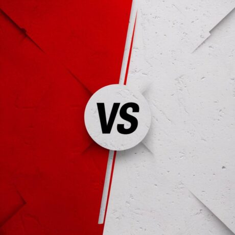 Imagem gráfica de comparação com fundo dividido ao meio: lado esquerdo vermelho e lado direito branco. No centro, um círculo branco exibe as letras “VS” em preto, simbolizando confronto ou comparação entre duas opções.