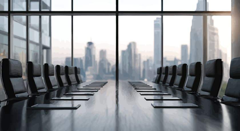 Uma sala de conferências corporativa moderna vista de cima, olhando para baixo em uma longa mesa de reuniões de madeira escura