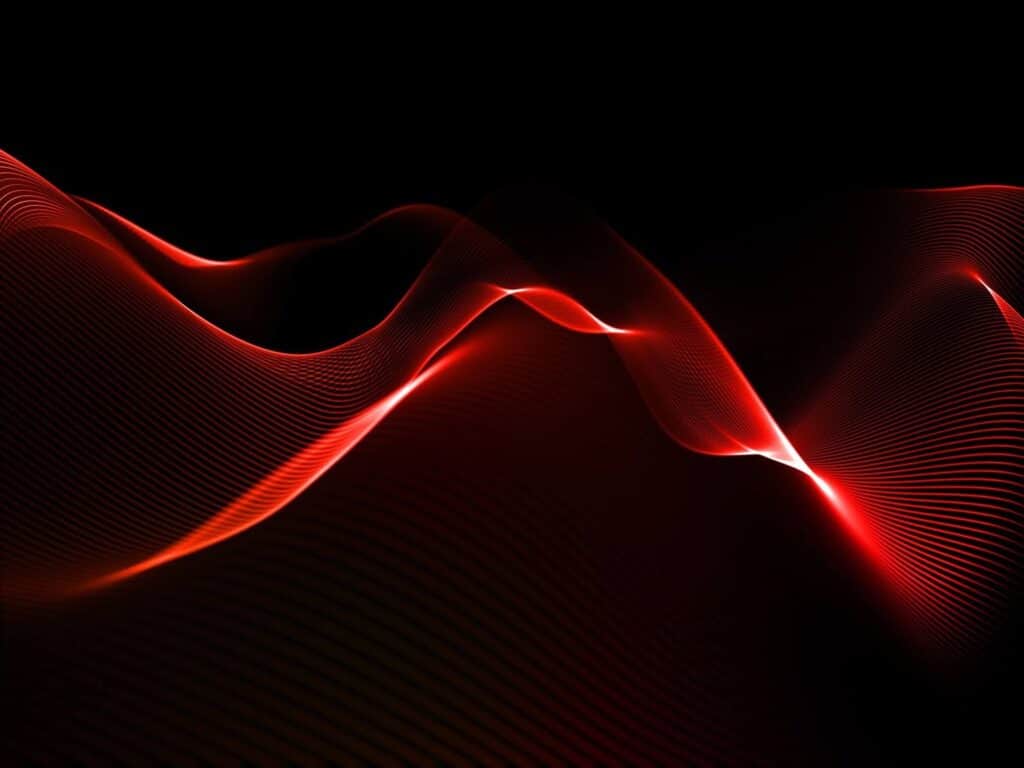 Imagem abstrata com linhas onduladas vermelhas sobre fundo preto, representando fluxo de energia ou sinal elétrico.