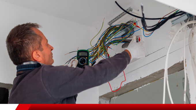 Eletricista medindo fiação elétrica com multímetro