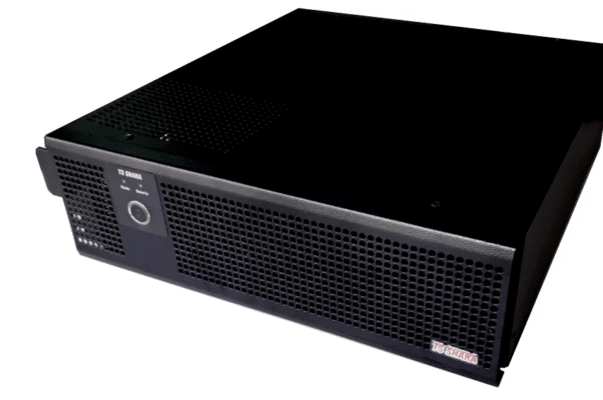 Equipamento TS Shara preto em formato horizontal, parecido com nobreak para rack, com grade frontal de ventilação e botão circular no painel. O produto aparece sobre fundo branco.