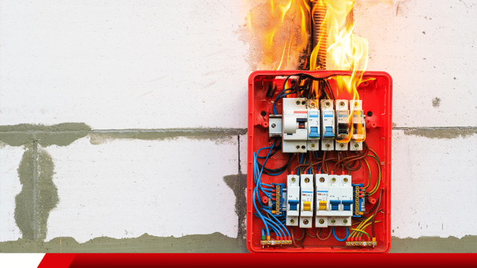 Quadro elétrico aberto pegando fogo na parede