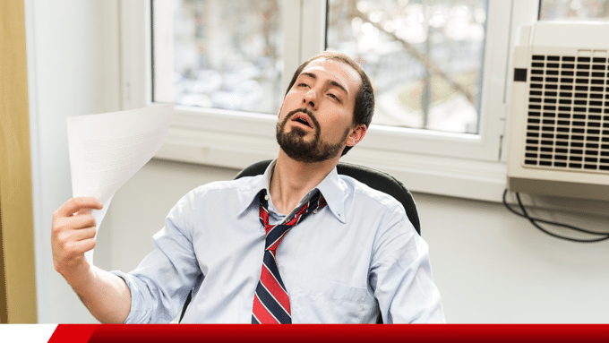 Homem sente calor ao lado de ar-condicionado.